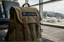 Load image into Gallery viewer, Custom flag name patch on a travel backpack at the airport
